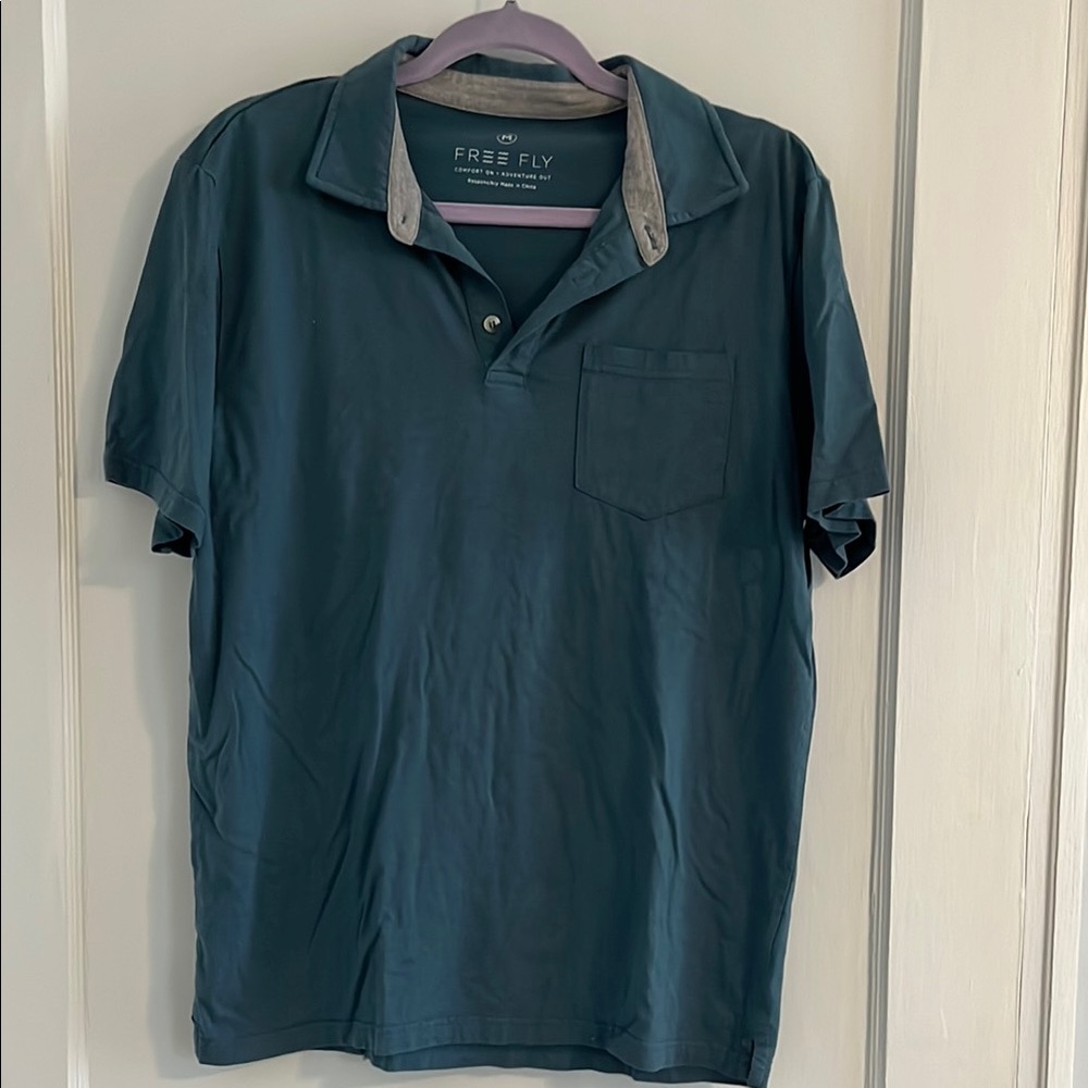 Men’s blue free fly polo with pocket. Size M